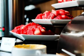 A buffet with watermelon slices on white plates. - News Hotel Surabaya by Graha Pena Jawa Pos (Sidoarjo)