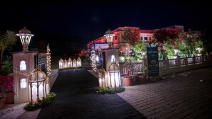 A well-lit entrance with ornate lanterns and a welcoming sign. - Hotel Raj Bagh Palace (Amer)
