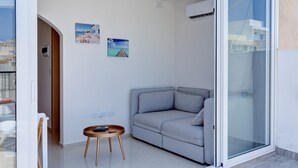 Una sala de estar moderna con un sofá gris, una mesita de madera y dos cuadros colgados en la pared.