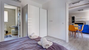 A modern hotel room with a bed, a bathroom, and a dining area. - Modern Apartment Just off the Promenade (Sliema)