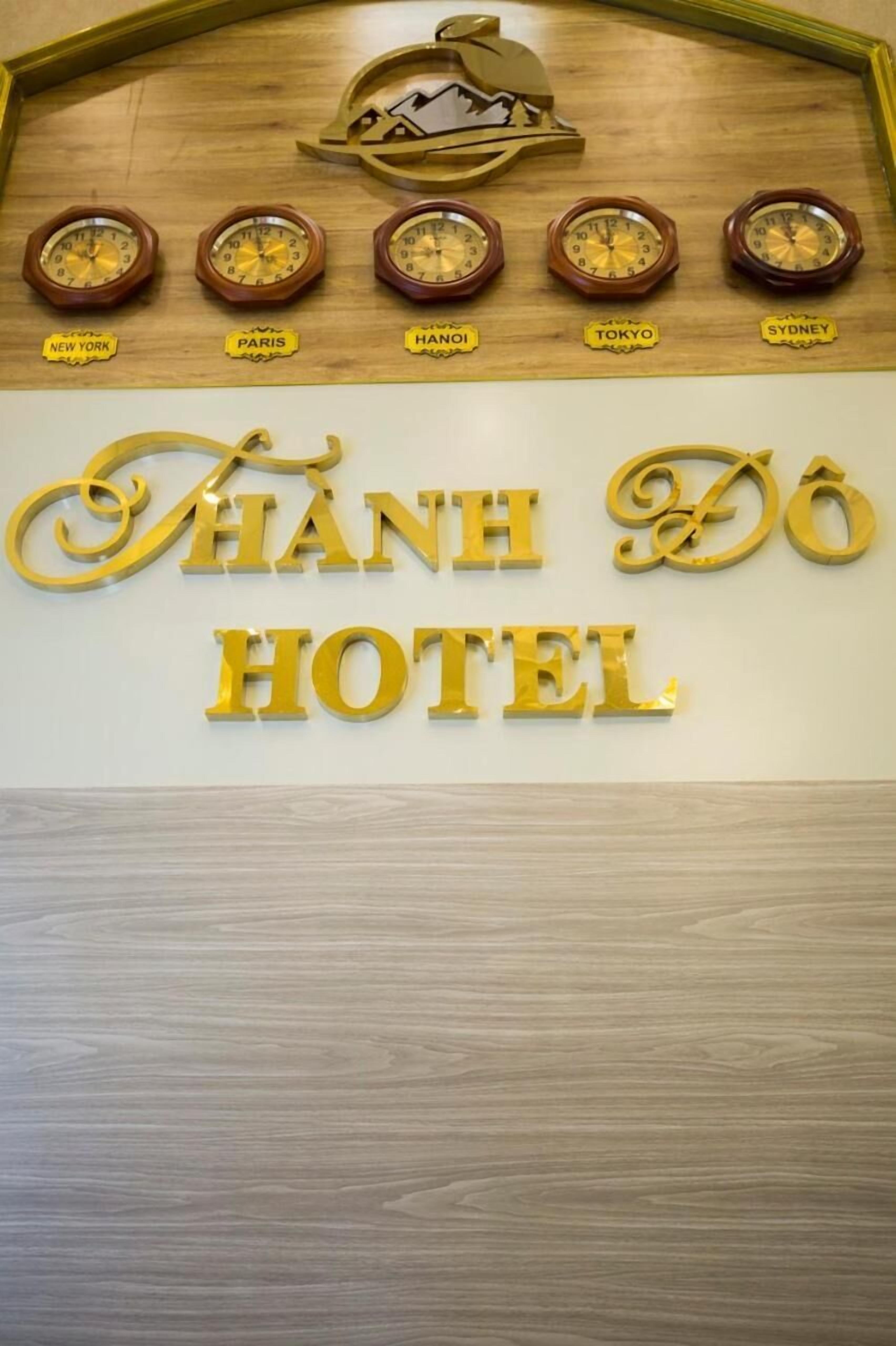 Una pared con relojes que marcan la hora en diferentes ciudades y el texto "HÀNH DÔ HOTEL".