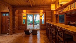 L’intérieur d’un chalet en bois comprend un bar, une table ronde et des chaises.