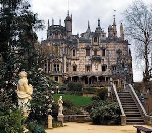 A historic building with ornate architecture, a central courtyard, and a staircase leading to the entrance.