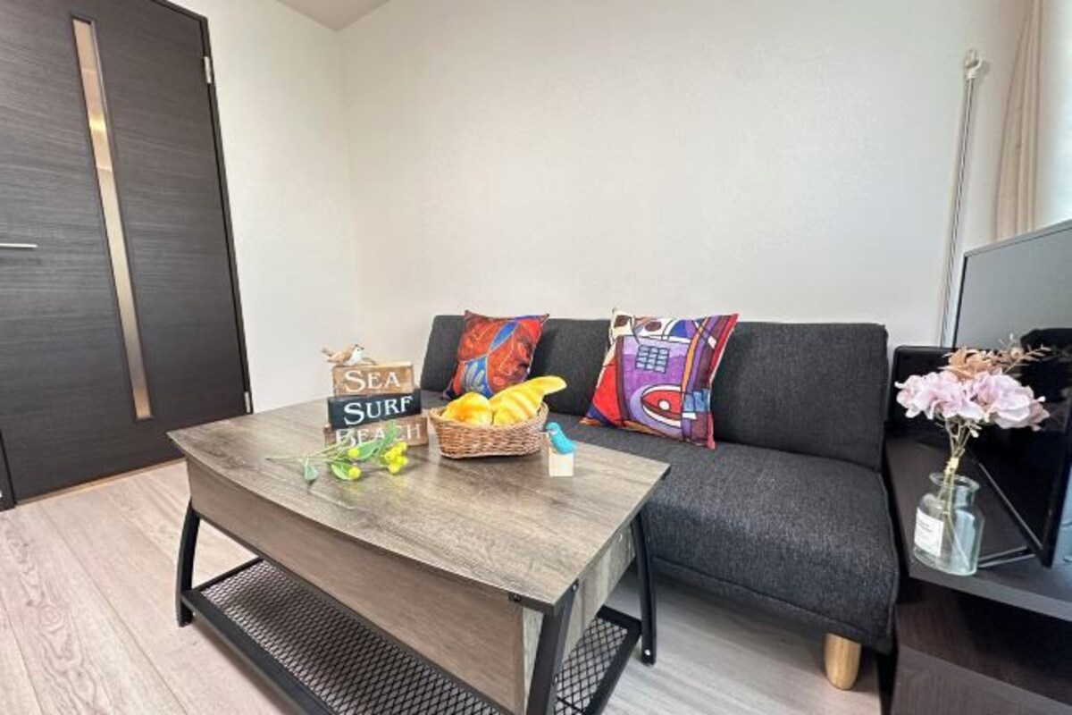 A modern living room with a sofa, a coffee table, and a television.