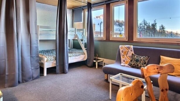 A cozy cabin interior with a bunk bed, a sofa, and a glass coffee table. - Spacious studio with wifi in Plagne Centre, near slopes (La Plagne)