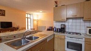 Una cocina moderna con estufa a gas, microondas y pileta doble.
