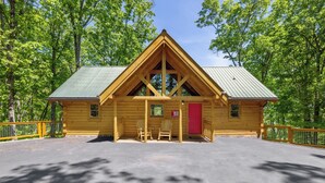 A log cabin with a green roof, wooden exterior, and a red door. - Moonlight Obsession, a Secluded Dog-Friendly Cabin located just minutes from downtown Gatlinburg (Gatlinburg)