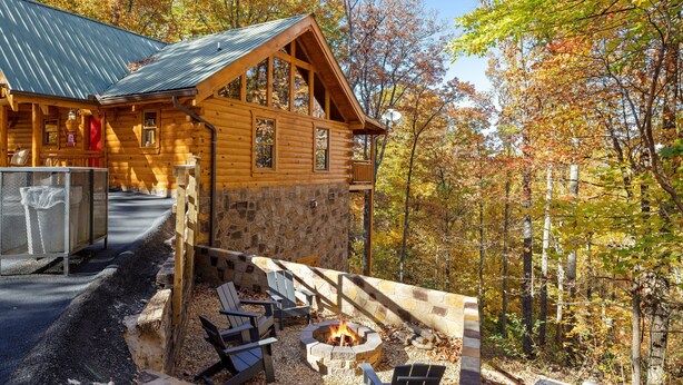 A log cabin with a stone foundation, a fire pit, and outdoor seating. - Moonlight Obsession, a Secluded Dog-Friendly Cabin located just minutes from downtown Gatlinburg (Gatlinburg)