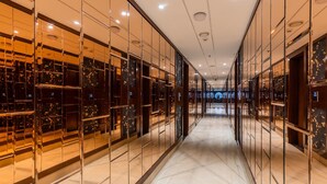 A corridor with mirrored walls and a marble floor, leading to a large open space with a view of the sky. - Skyline Resort & Convention Centre (Indore)