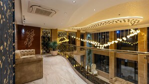 A luxurious lobby with a curved ceiling, plush seating, and a decorative tree wall. - Skyline Resort & Convention Centre (Indore)