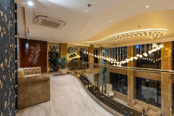 A luxurious lobby with a curved ceiling, plush seating, and a decorative tree wall. - Skyline Resort & Convention Centre (Indore)
