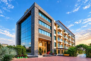 A modern hotel with a glass facade, multiple balconies, and a landscaped entrance area. - Skyline Resort & Convention Centre (Indore)