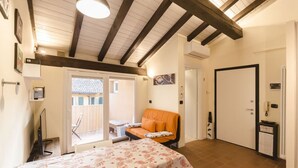 A room with a dining table, a sofa, and a door. - Ca' di Leo (Bologna)