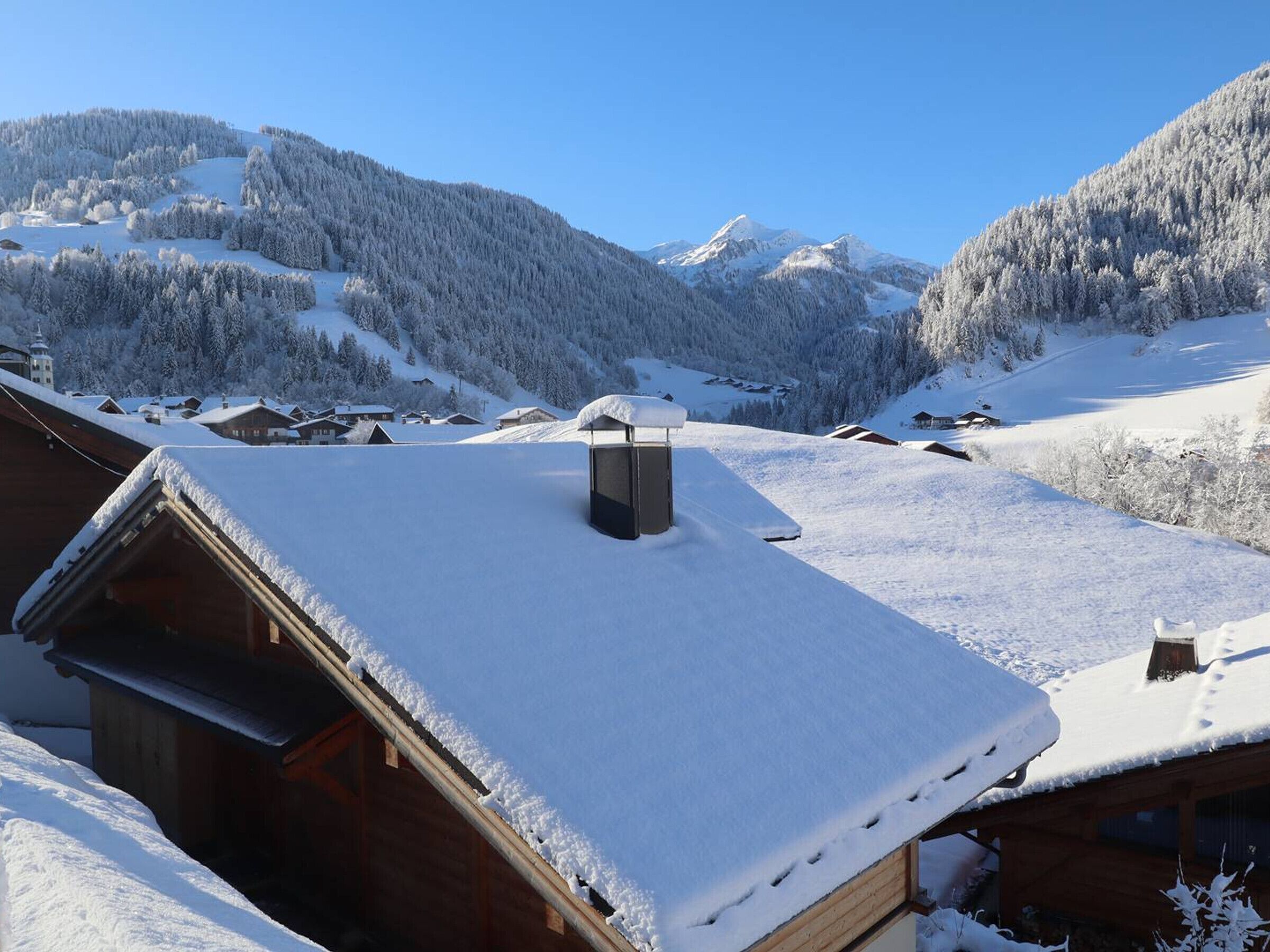 Eine verschneite Berglandschaft mit Holzhütten.