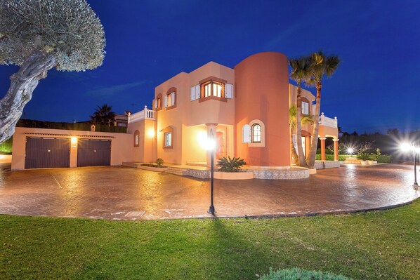 A large, multi-story house with a driveway and a well-maintained lawn. - Villa close to Ibiza Town Sleeps 12 (Can Bessó)