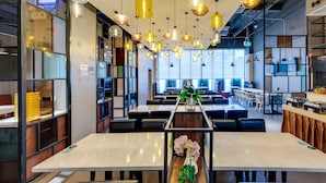 A modern restaurant with high ceilings, pendant lighting, and a central walkway. - W Kardon Hotel (Guangzhou)