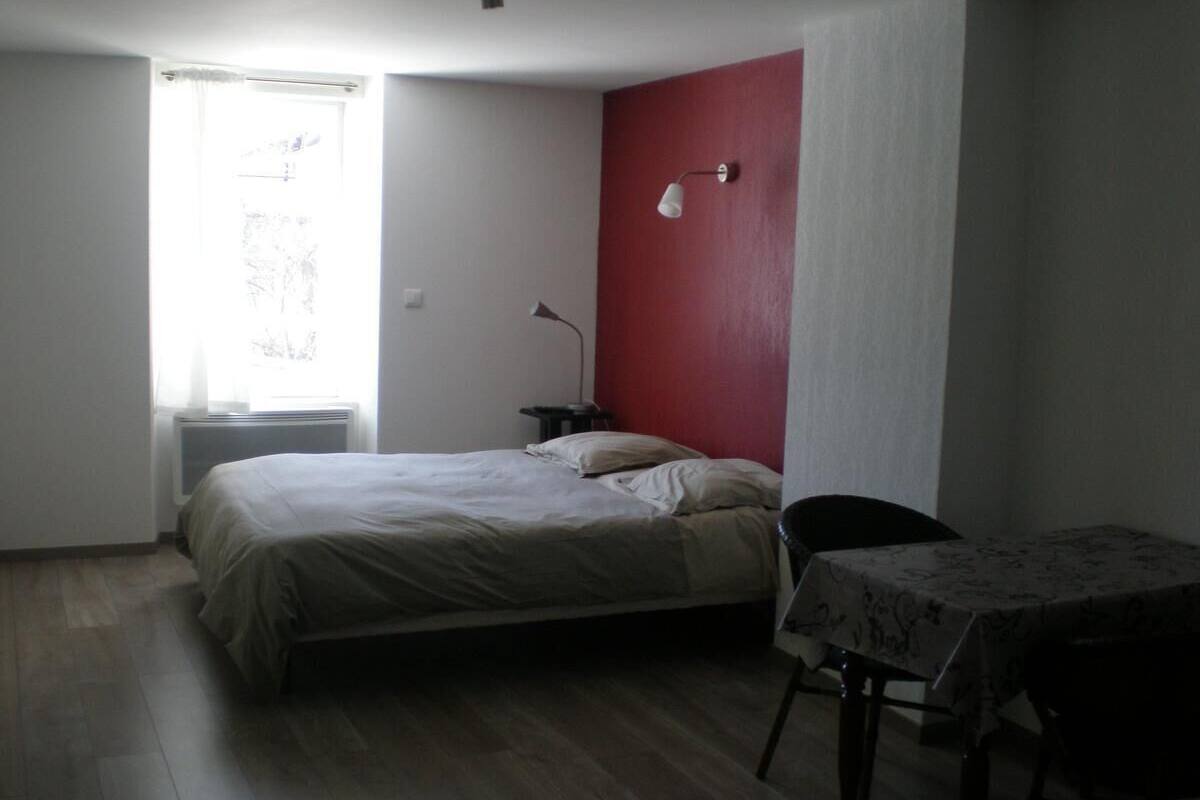 A room with a bed, a table, and a chair.