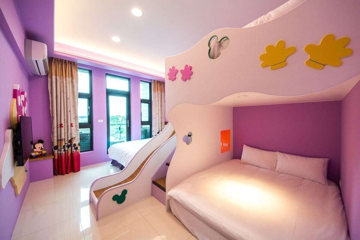 A child-friendly room with a bunk bed, a slide, and a Mickey Mouse figurine.