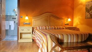 A hotel room with a bed, nightstands, a wooden chair, and a bathroom visible through an open door. - Hotel Valle del Silencio (Ponferrada)