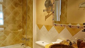 Un bagno con una vasca, un lavabo con una bacinella marrone e un water.