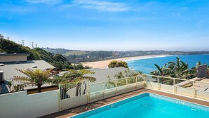 Piscina con vista a una playa y al océano.