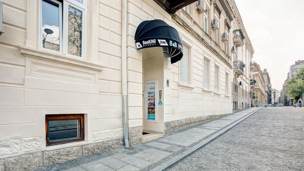 A building with a black awning labeled "Booking B&B." - Booking BnB (Belgrade)