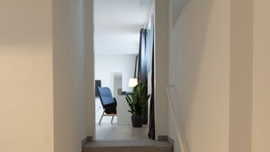A staircase leading to a room with a chair and a potted plant. - Dreams Bielefeld (Bielefeld)