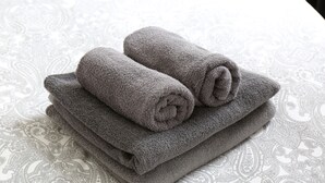 A stack of folded gray towels on a patterned tablecloth. - Dreams Bielefeld (Bielefeld)