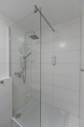 Habitación clásica doble | Baño | Ducha, secador de pelo, toallas y papel higiénico