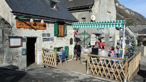 A rustic stone building with a wooden deck and outdoor seating area. - House / Villa - VIGNEC (Vignec)