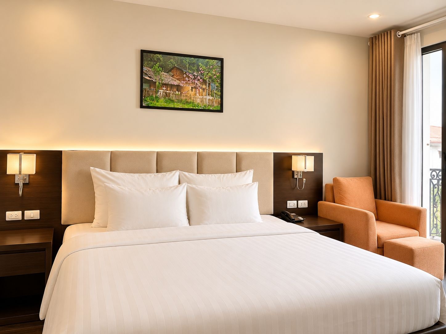 A hotel room with a bed, two bedside lamps, a chair, a painting on the wall, and a window with curtains.