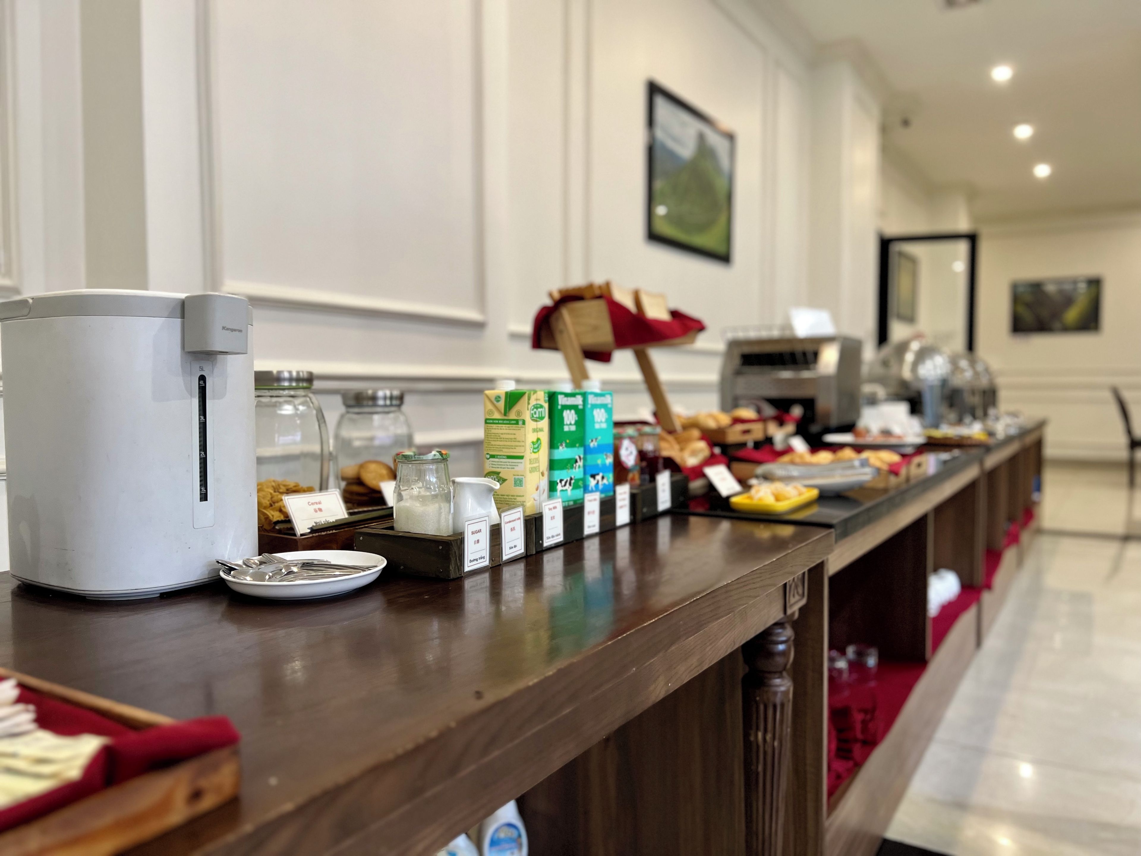 A breakfast bar with a coffee machine, condiments, and food items.