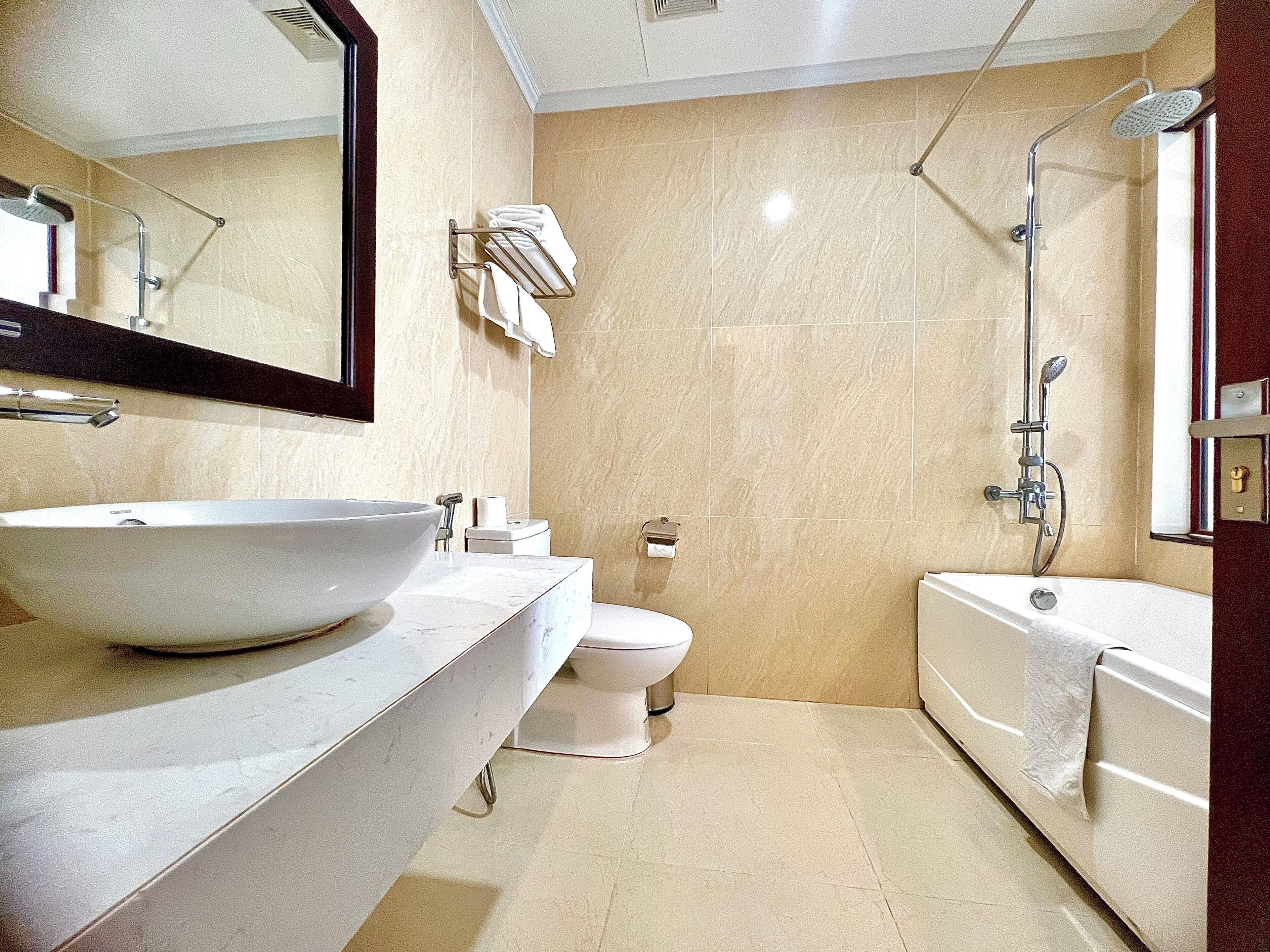 A bathroom with a large sink, toilet, and bathtub.