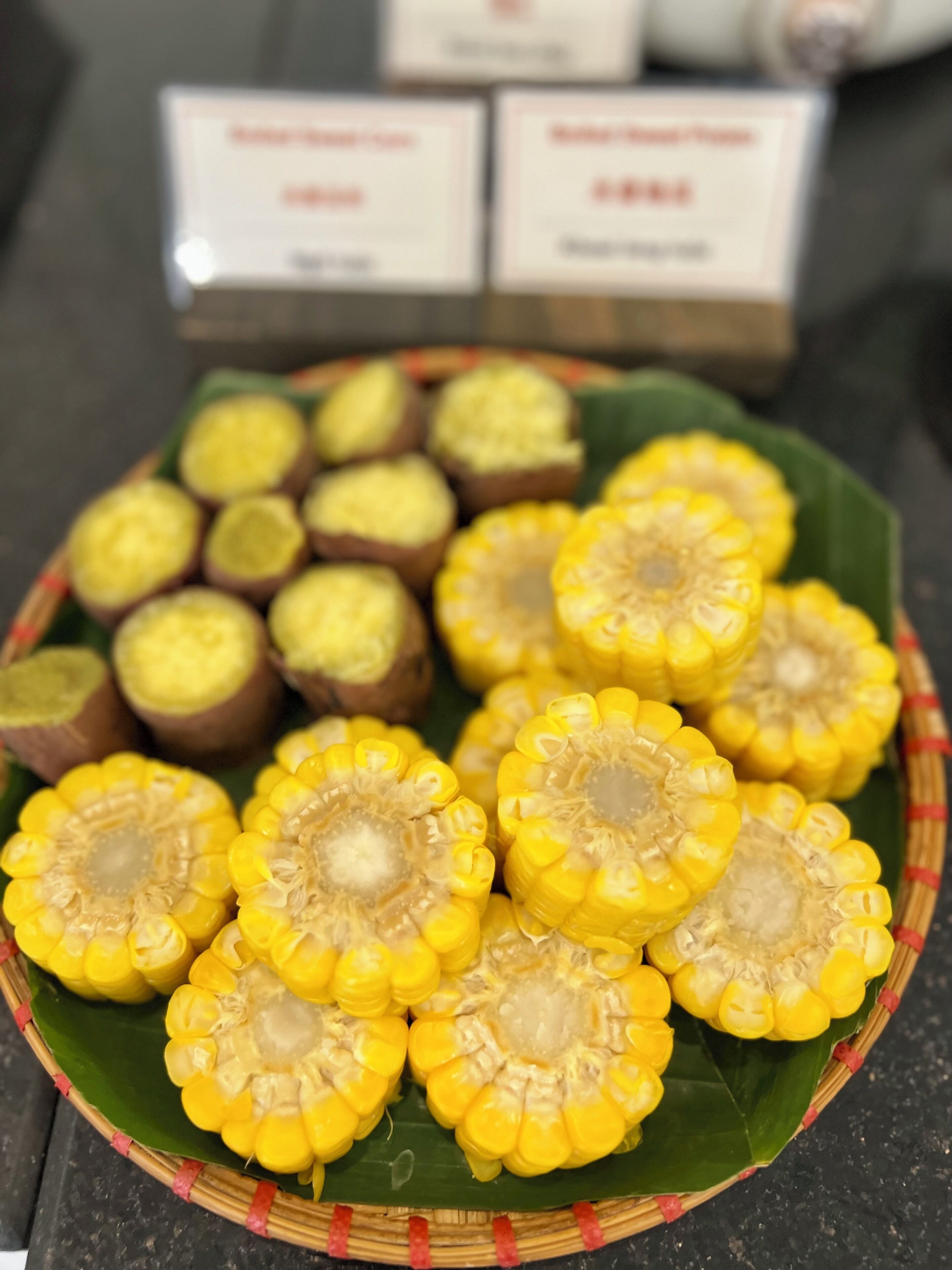 Una cesta con mazorcas de maíz y una hoja verde debajo.