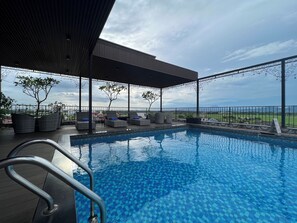Ein Poolbereich mit Liegestühlen und Blick auf die Landschaft.