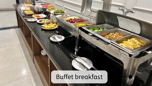 Montaje de desayuno tipo buffet con diversos alimentos y utensilios.