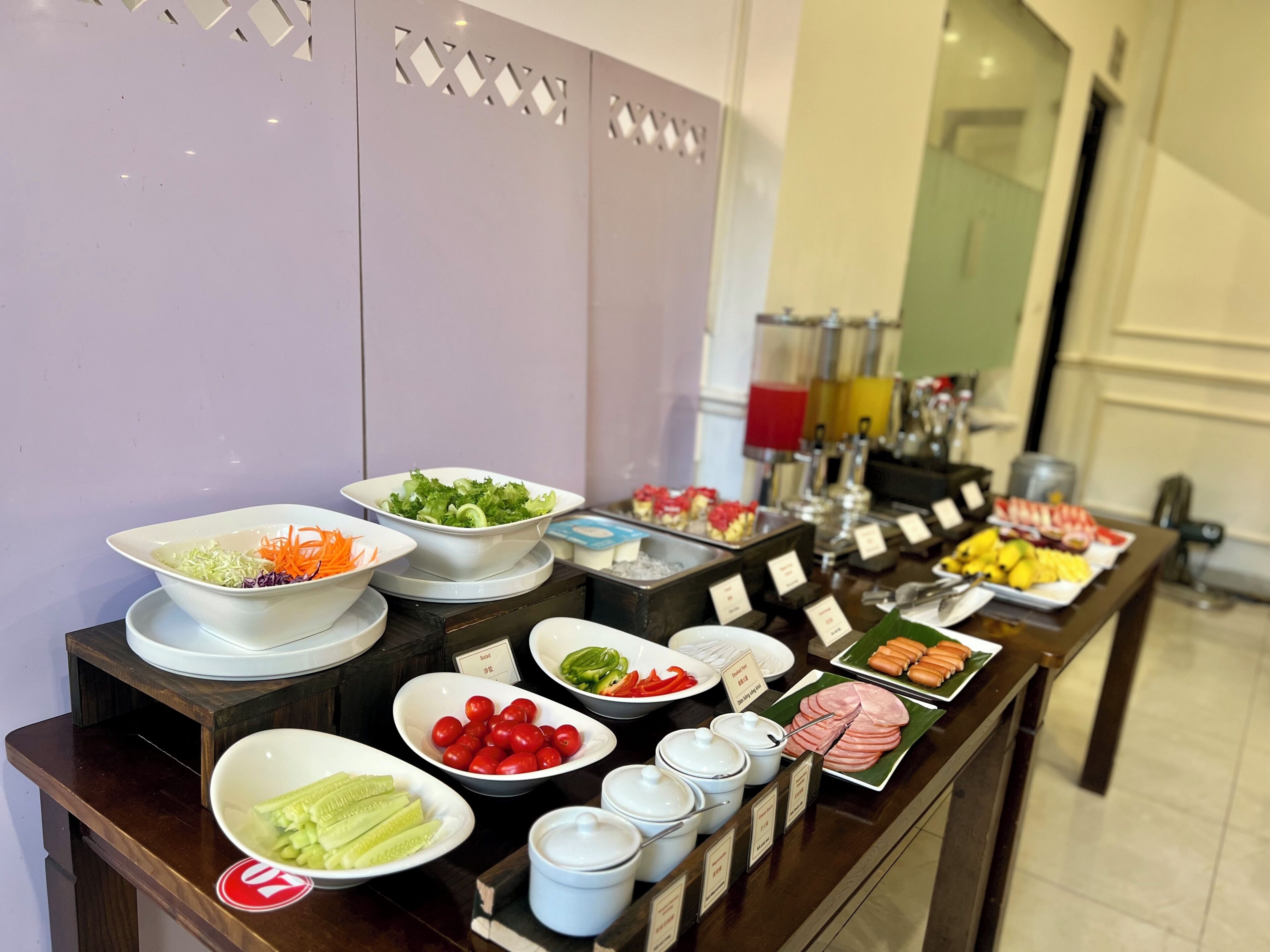 A buffet table with various food items and condiments.