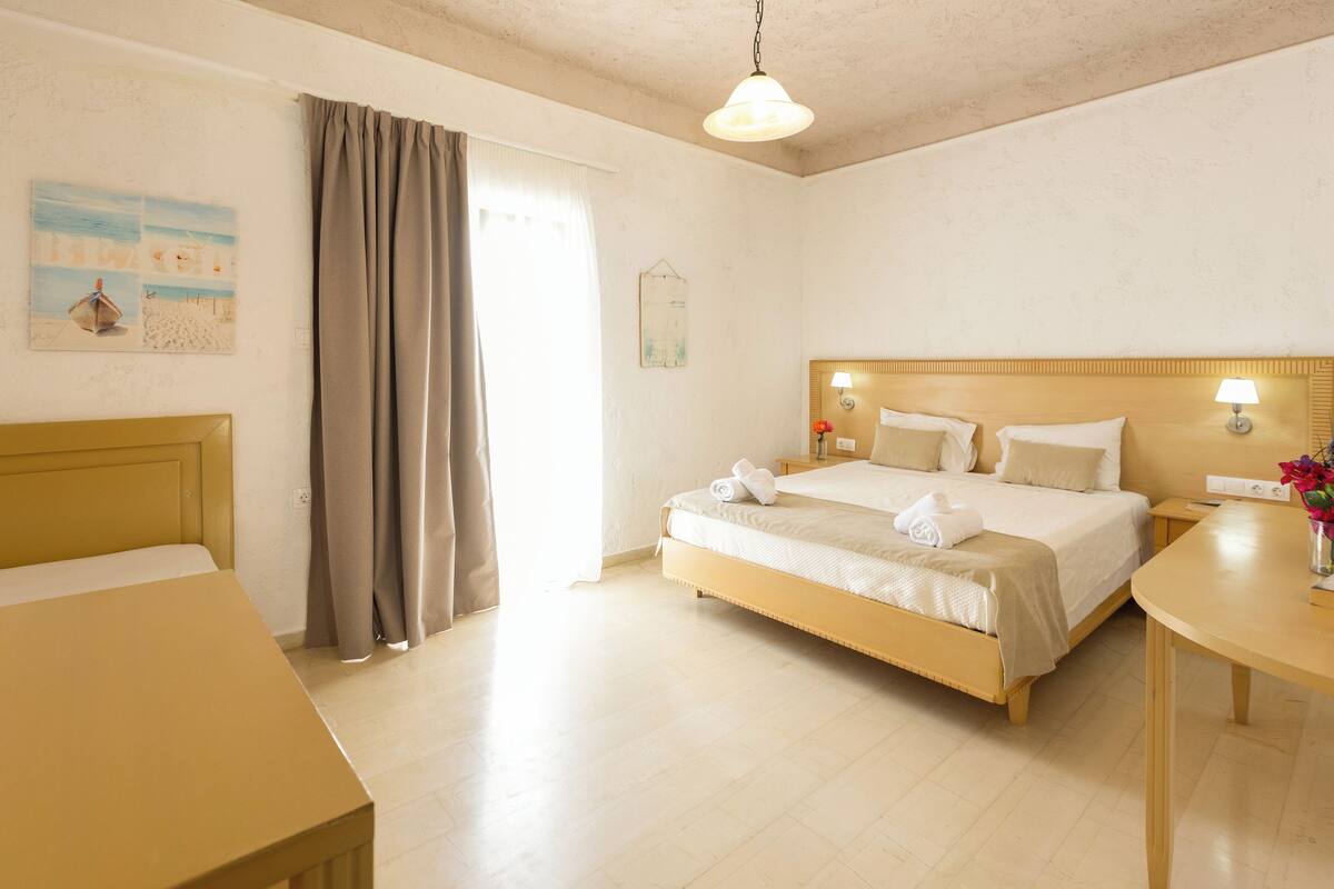 Ein Hotelzimmer mit Bett, Nachttisch und Schreibtisch.