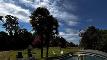 Una piscina al aire libre de temporada, sombrillas