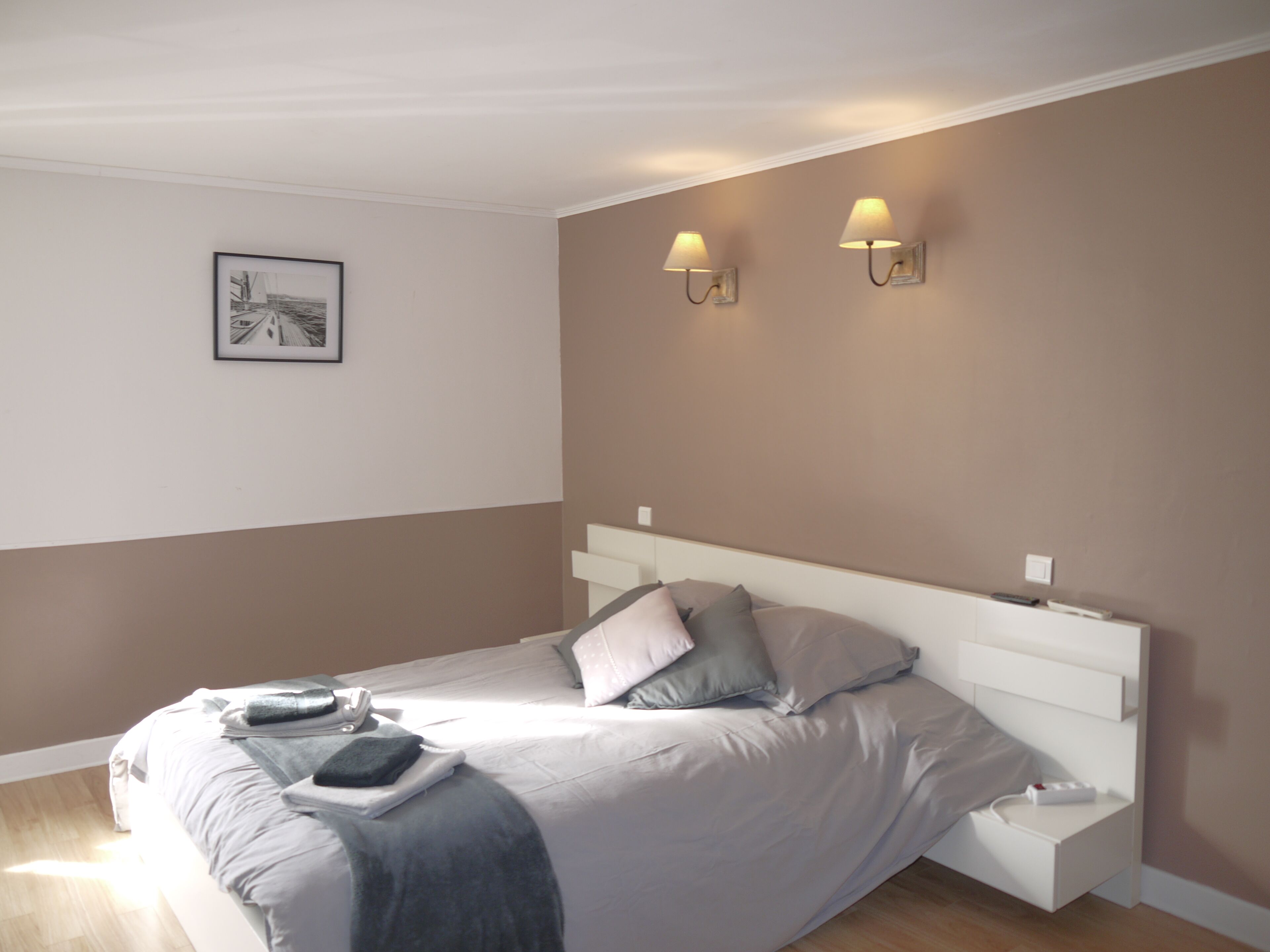Una camera da letto moderna con un letto, comodini e illuminazione a parete.