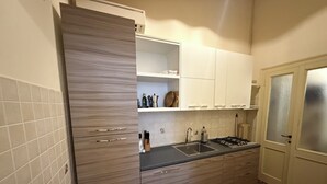 A modern kitchen with wooden cabinets, a stainless steel sink, and a built-in oven. - Charming apartment in Venetian palace overlooking the canal, a / c and free wifi! (Venezia)