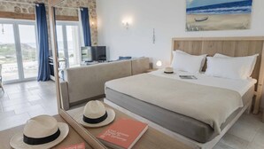 Une chambre avec un lit, une télévision et une vue sur la plage par la fenêtre.