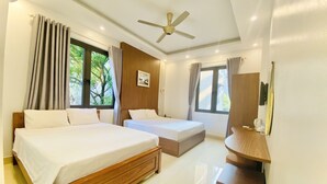 A hotel room with two beds, a ceiling fan, a wooden vanity, a mirror, and a window with curtains. - O Zoli Home (Ninh Binh)