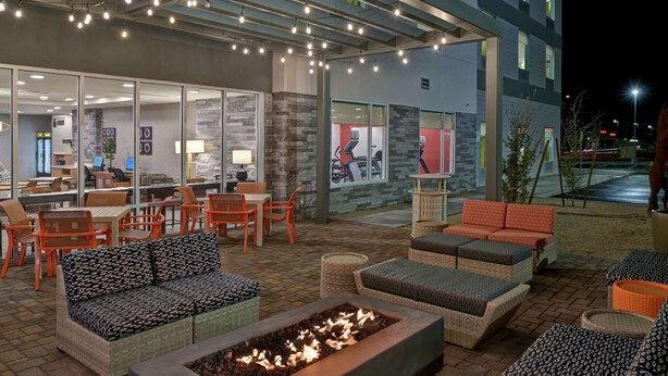 Un espace extérieur aménagé avec un foyer, des tables et des chaises.