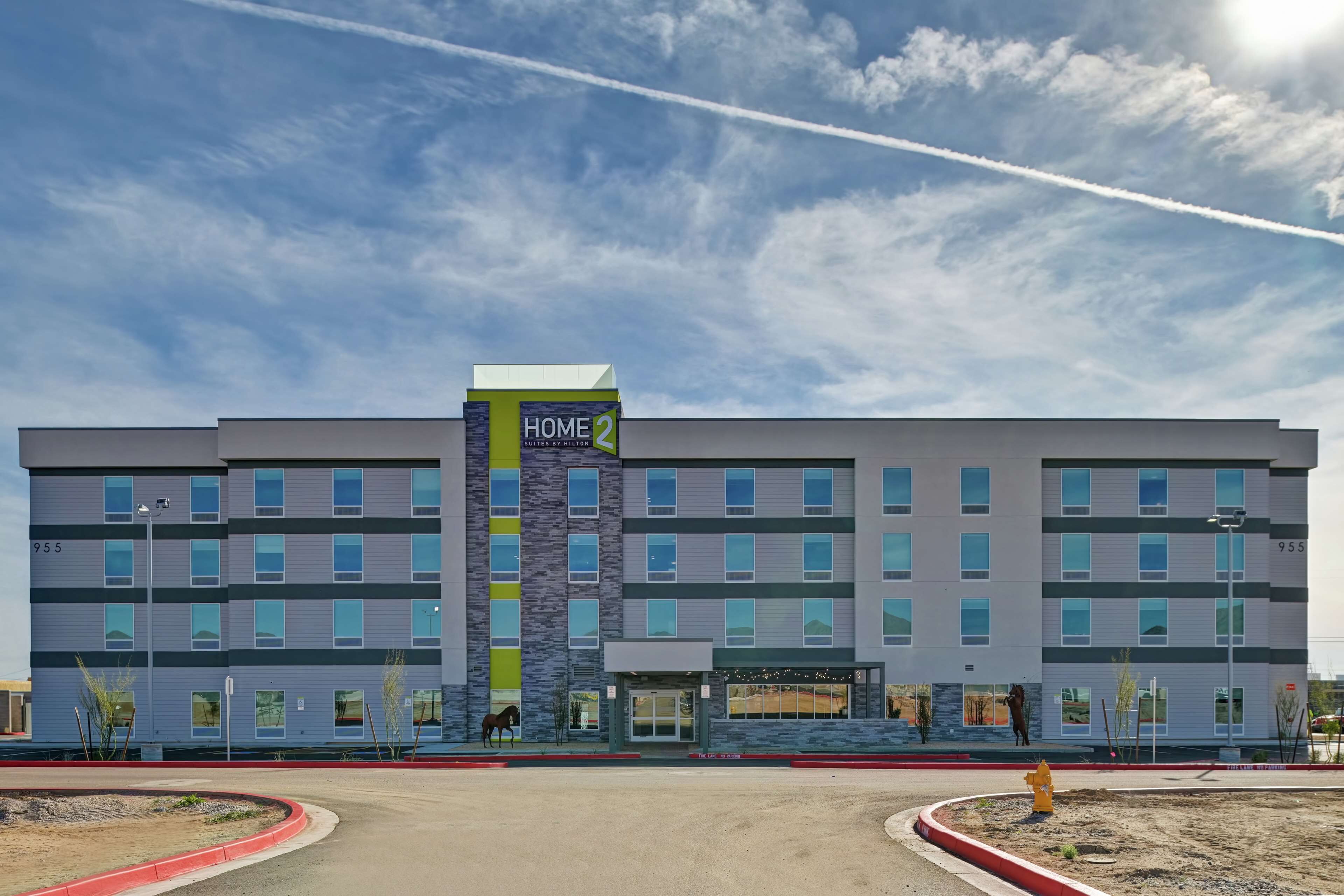 Un moderno edificio de hotel con un cartel que dice 'HOME 2 SUITES BY HILTON'.