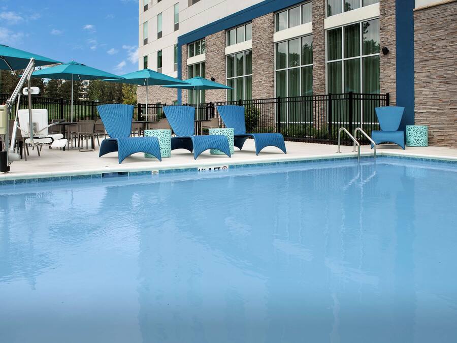 Ein Poolbereich mit Liegestühlen und Sonnenschirmen.