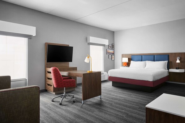 Une chambre d’hôtel équipée d’un lit, d’un bureau, d’une chaise et d’un téléviseur.