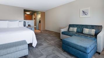 Una habitación de hotel moderna con una cama grande, un sofá y una mesita.
