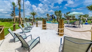 A poolside area with lounge chairs, palm trees, and a clear sky. - Ev7825ha - Storey Lake Resort - 5 Bed 5 Baths Unspecified (Kissimmee)