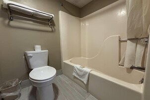 Un baño con inodoro, bañera y cortina de ducha.
